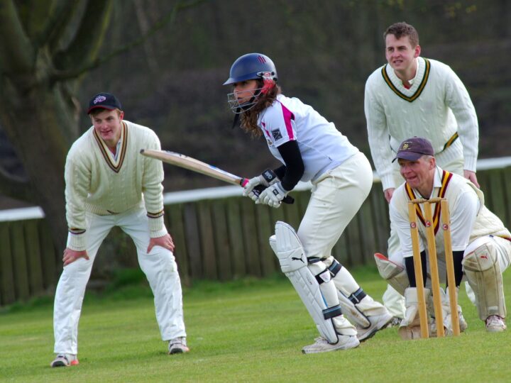 People playing cricket to encourage cricketer